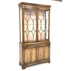 Reproduction mahogany Georgian style display cabinet, projecting dentil cornice above arcade frieze, two astragal glazed doors enclosing adjustable glass shelves, the lower section with leather inset slide and cupboard enclosed by two figured doors, on bracket feet, W115cm, H214cm, D39cm