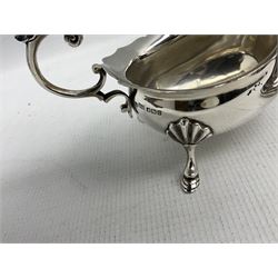 Silver circular capstan inkwell with hinged lid engraved with initials H6cm Birmingham 1924 Maker Deakin & Francis and a silver sauce boat with C scroll handle Sheffield 1916 (2)