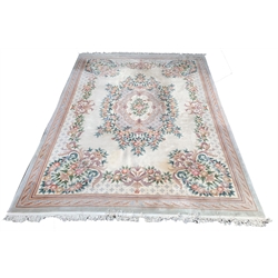 Large Chinese washed wool carpet with floral medallion and spandrels on an ivory field enclosed by border, 