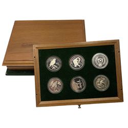 The 'Conservation Coin Collection', comprising twenty-four silver proof coins, housed in a wooden display case, each coin approximately 28 grams