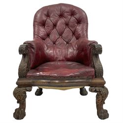 Victorian oak framed library armchair, arched back in buttoned red leather, scrolled arm terminals and uprights carved with acanthus leaves, serpentine seat, acanthus carved ball and claw feet