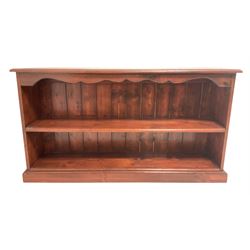 Stained pine low bookcase, moulded rectangular top over shaped frieze and shelf, plinth base