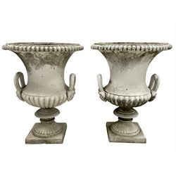 Pair white painted cast iron Campana shaped garden urns, gadroon moulded rim and underbelly, fitted with mask handles, on moulded stem and square base
