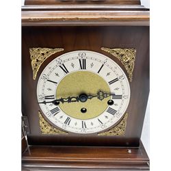A 20th century three train mantle clock in the style of an 18th century bracket clock, case with an inverted bell top and basket top handle, square brass dial with a slivered chapter ring, roman numerals and five-minute Arabic’s, decorative steel hands with a matted dial center and cherub spandrels, striking the hours and quarters on five gong rods.