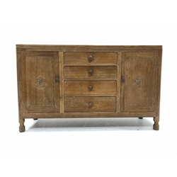 Wilf 'Squirrelman' Hutchinson of Husthwaite - Yorkshire oak sideboard, raised on over rectangular top with canted corners, bank of four graduated drawers flanked by two fielded cupboards carved with Yorkshire rose roundels, each enclosing a shelf, raised on octagonal turned supports 