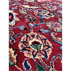 Persian Meshed red and blue ground carpet, floral medallion on busy red field enclosed by border 252cm x 363cm