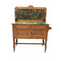 Early 20th century oak washstand, raised marble back and top over two geometric panelled doors with a towel rail at one end, raised on turned supports united by a stretcher terminating in castors