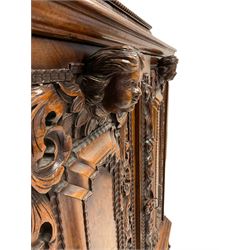 19th century walnut cupboard, carved with foliage scrolls, masks and ribbons and fitted with one cushion drawer over two cupboard doors opening to reveal two fixed shelves and one long drawer, raised on ball and claw feet 