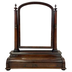 Mid-19th century mahogany toilet mirror, the arched mirror in chamfered slip and supports by two tapered columns with finial, the piano lid front hinges to reveal compartment, lower mould on compressed bun feet