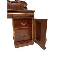 Early Victorian figured mahogany sideboard, raised back carved with foliage scrolls, fitted with three cushion frieze drawers with over twin pedestals, each with waisted door panels, enclosing shelves, on skirted base 