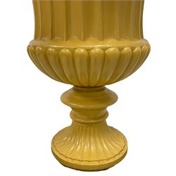 Campana shaped urn on pedestal, the urn with egg and dart moulded rim over fluted body with gadrooned underbelly, on stepped and moulded footed base, on a black painted pedestal of square tapered form