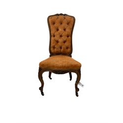 19th century walnut lady's salon chair, shaped and moulded frame with floral carved cresting, over-stuffed serpentine seat and buttoned back, scrolled cabriole supports carved with flower heads