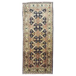 Azerbaijani ivory ground rug, the indigo field decorated with interconnecting divisions each enclosing geometric stylised plant motifs, the guarded border with repeating flower heads connected by foliage