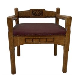 Set three (2+1) Arts and Crafts design ecclesiastical oak church chairs, the carver carved with central blind fretwork depicting cross and Greek letters, upholstered in maroon fabric, raised on chamfered supports