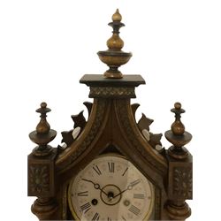 Juhngans - late 19th-century 8-day walnut and ebony mantle clock, with a spire pediment and canted plinth, matching turned finials, ring-turned half-pilasters and fully glazed door displaying a card dial with Roman numerals, moon steel hands and a faux twin file mercury pendulum, two train count wheel striking movement, striking the hours and half hours on a coiled going. With pendulum and key.
