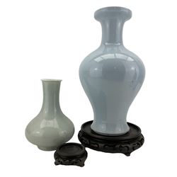 Chinese pale blue glaze baluster vase, blue seal mark beneath H34cm, together with a Chinese Celadon glazed vase with incised decoration, with matching hardwood stands (2)