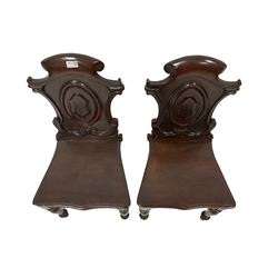 Pair 19th century mahogany hall chairs, carved shield-shaped scroll back raised on turned tapering front supports 