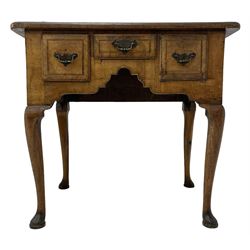 George II walnut lowboy, the rectangular top with boxwood and ebony stringing and moulded edge, fitted with a short central drawer flanked by two deeper drawers, each with foliate decorated brass plates and drop handles, the shaped and arched apron with cock-beaded lower edge, raised on cabriole supports terminating in pad feet