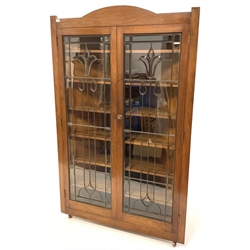 Early 20th century American walnut floor standing corner cupboard, with arched pediment over two copper glazed doors with bevelled glass enclosing five fixed shelves, W123cm, H194cm