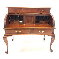 Georgian style mahogany roll top desk, fitted with three drawers over tambour front enclosing correspondence shelves, drawers and cupboards, two drawers under, raised on cabriole supports W115cm, H110cm, D65cm 