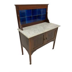 Edwardian mahogany washstand, the blue tiled back and marble top, over two cupboards with satinwood inlay, raised on squared supports, terminating in castors