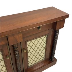 19th century walnut chiffonier or side cabinet, rectangular top over two drawers and two cupboards, enclosed by brass grille doors with fabric linings, ring turned upright columns, on plinth base 