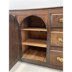 18th century and later oak dresser base, with one central cupboard opening to reveal two fixed shelves, flanked by six graduated drawers, raised on bracket feet 