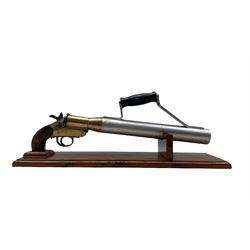 Early 20th century Schermuly line throwing pistol, walnut grip, brass body stamped SPRA and numbered 8704 and steel barrel, mounted on pine display stand, L50cm 
