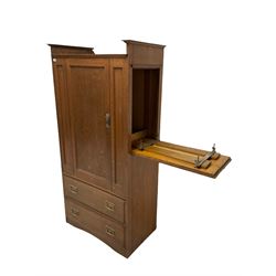Oak wardrobe with one panelled door opening to reveal interior fitted for hanging with a falling side trouser press over two long drawers, raised on a skirted base W96cm, H194cm, D56cm 