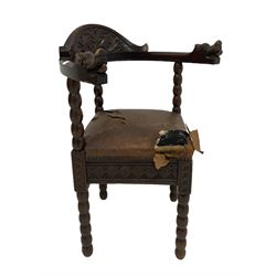 Oak corner chair with blind carved back rail over leather seat, raised on turned bobbin supports 
