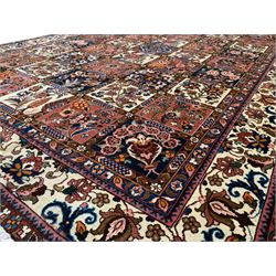 Persian Bakhtiari garden rug, the field divided into panels each decorated with floral designs and tree of life motifs, the border decorated with scrolls and stylised peony motifs, within guards