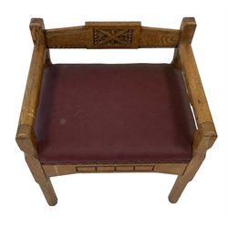Set three (2+1) Arts and Crafts design ecclesiastical oak church chairs, the carver carved with central blind fretwork depicting cross and Greek letters, upholstered in maroon fabric, raised on chamfered supports