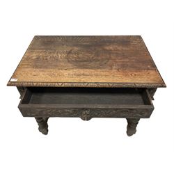 Late 19th century gothic revival oak side table, rectangular top with moulded and carved edge, the single drawer carved with green man handle flanked by trailing foliage, the corners applied with carved flower head motifs, raised om spiral turned supports united by barleytwist stretcher