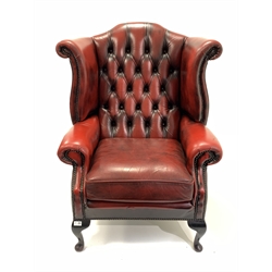 20th century wingback armchair, upholstered in deep buttoned and studded oxblood leather, raised on cabriole front supports, W82cm