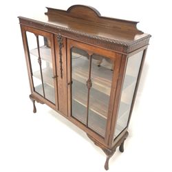 Early 20th century walnut display cabinet, raised back over gadroon moulded top, two glazed doors enclosing two shelves, raised on acanthus leaf carved cabriole supports W124cm, H141cm, D32cm