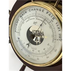 Nautical themed aneroid barometer and thermometer, white enamel dial enclosed by a bevel glazed bezel, brass bulk head case with ships wheel, on circular oak mount D33cm
