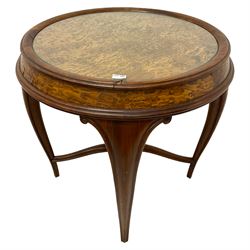 Late 19th century elm and walnut centre table, circular top with glass inset, on four cabriole supports with scroll carvings, joined by shaped and moulded stretchers with central flower head carved finial