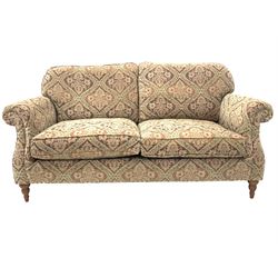 Parker Knoll three seat sofa, with squab cushions, upholstered in floral fabric, raised on turned front supports W194cm H