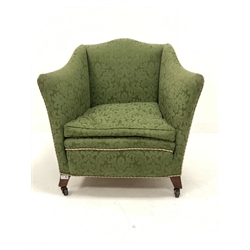 Edwardian easy armchair of square form, upholstered in green Damask, with squab cushion, raised on square tapered and splayed front supports terminating in castors, W80cm