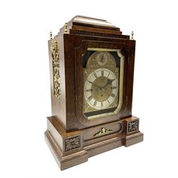 English oak cased bracket clock - in a late 19th-century case with a brass dial inscribed Thwaites, London, with a flat-topped stepped pediment and silk backed brass sound frets to the sides, standing on a conforming stepped plinth, silvered chapter ring with Roman numerals and minute track, pierced steel hands and engraved dial centre, with cast spandrels and pendulum regulation dial to the break arch, 8-day three train chain fusee movement chiming the quarters and striking the hours on a nest of 8 bells plus one, with a recoil anchor escapement and a London regulation pendulum. With key.