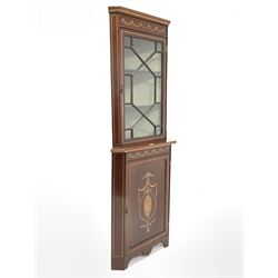 Edwardian mahogany floor standing display cabinet, dentil cornice over swag and chequered band inlay and astragal glazed door enclosing two shelves, the bottom section fitted with panelled cupboard with further swag and floral inlay enclosing a shelf, raised on bracket supports W73cm, H193cm, D51cm