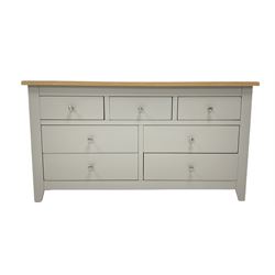 Modern sideboard, the light oak top over three short and four longer drawers, raised on stile supports 