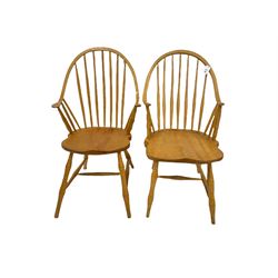 Two light elm American style Windsor carver armchairs, stick and hoop back with dished seats, turned supports joined by swell turned H stretchers