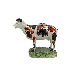 Two Victorian Staffordshire cow creamers, each naturalistically modelled with a milkmaid seated to one side with pail, on shaped rectangular bases, together with a 19th century Swansea pearlware cow creamer, the body painted with black and iron red markings, on green oblong base and one other (4)