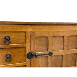'Oakleafman' oak dresser base, all-over adzing, fitted with four short central drawers and two cupboards, wrought metal fittings, panelled doors and sides, the right-hand side carved with leaf signature, by David Langstaff of Easingwold