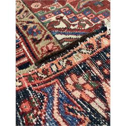 Persian ground rug, the red field with geometric design enclosed by a navy border 315cm x 235cm