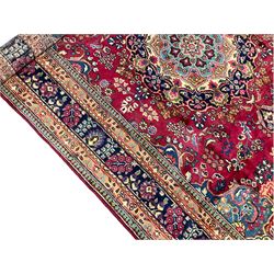 Persian fuschia ground rug, the central floral pole medallion surrounded by floral decoration, the blue spandrels with scrolling edges and flowerheads, the guarded border decorated with repeating stylised plant motifs