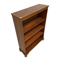 Late 20th century yew open bookcase, the crossbanded top over three adjustable shelves, raised on ogee supports 