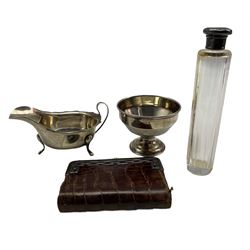 Silver sauce boat with crimped rim and loop handle Sheffield 1955 Maker Viners, small silver pedestal bowl D9cm Birmingham 1945, crocodile purse with silver mounts, import marks 1904 and a glass toilet bottle with silver cover 