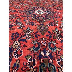 Iranian red ground rug, deep blue, red, ivory and green medallion on field decorated with urns and stylised foliate 259cm x 164cm